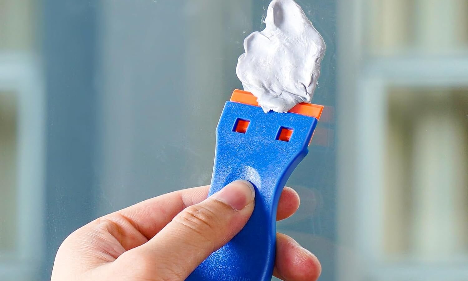 Glasfläche mit verbliebenen Aufkleberresten in ruhiger Umgebung.