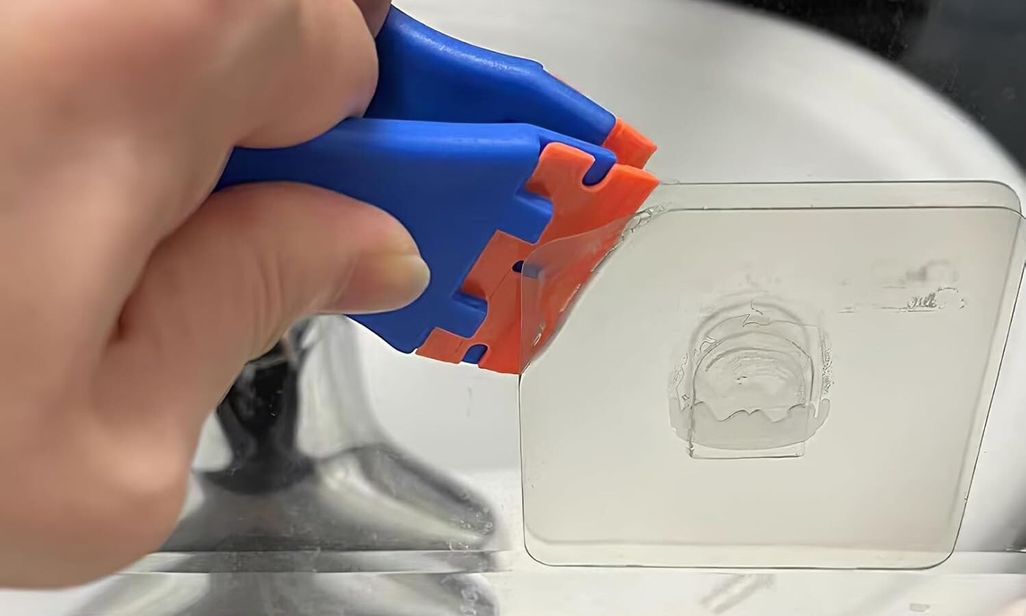 Kunststoffwerkzeug liegt neben einem Metallwerkzeug auf einer glatten Oberfläche.